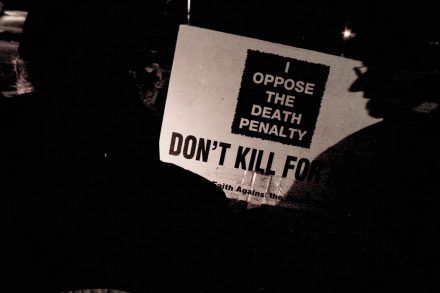 Image of an anti-death penalty campaign march with a banner stating 'I oppose the death penalty'. Photo is by Scott Langley